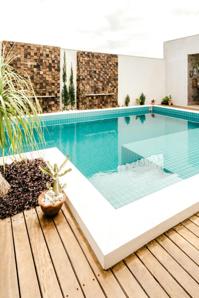 Comfortable lounge zone with swimming pool with clear water on terrace of modern villa in daytime